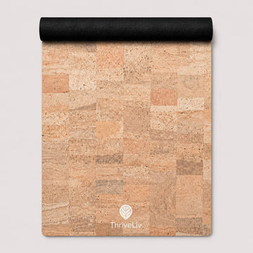 A cork mat with a natural cork patchwork pattern in shades of beige, tan, and brown, featuring a black rolled edge at the top and a white ThriveLiv logo at the bottom.