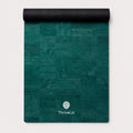 A teal green yoga mat with a textured patchwork design, partially unrolled to show its black underside. The brand name 'ThriveLiv' is printed in white near the bottom center.