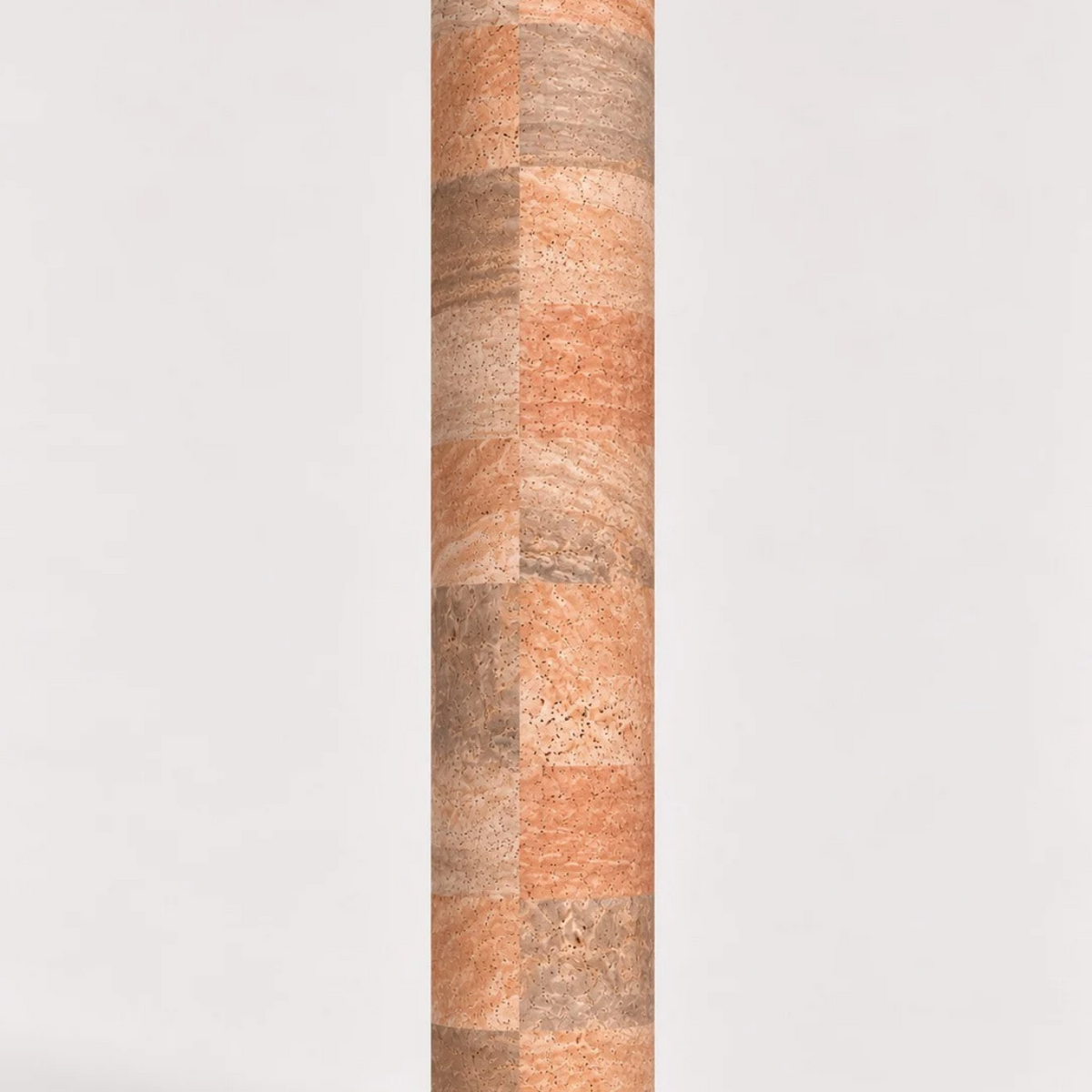 Rolled ThriveLiv natural cork yoga mat standing upright against a soft off-white studio background, showing the neutral cork pattern and texture.