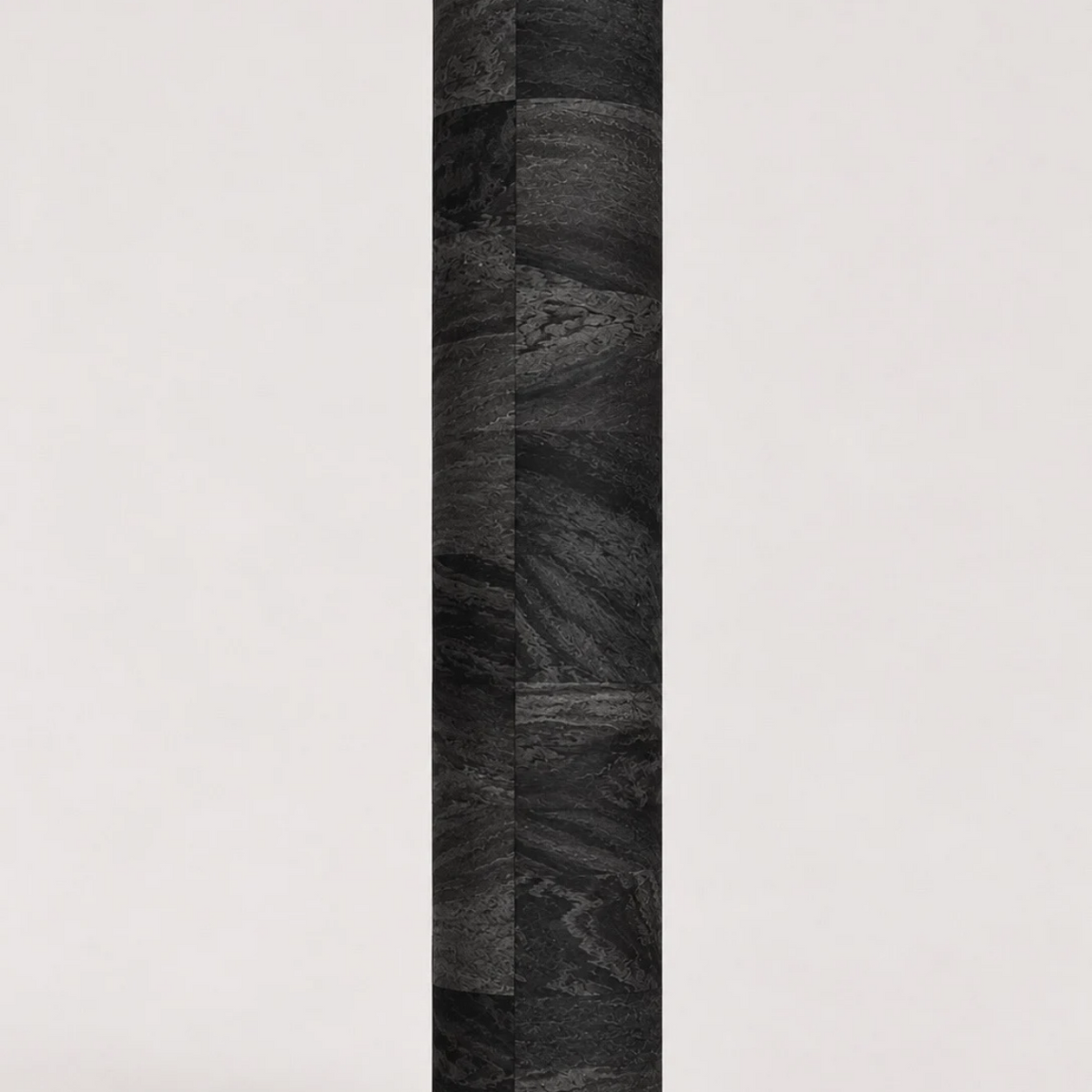Rolled ThriveLiv natural cork yoga mat standing upright against a soft off-white studio background, showing the dark cork pattern and texture.