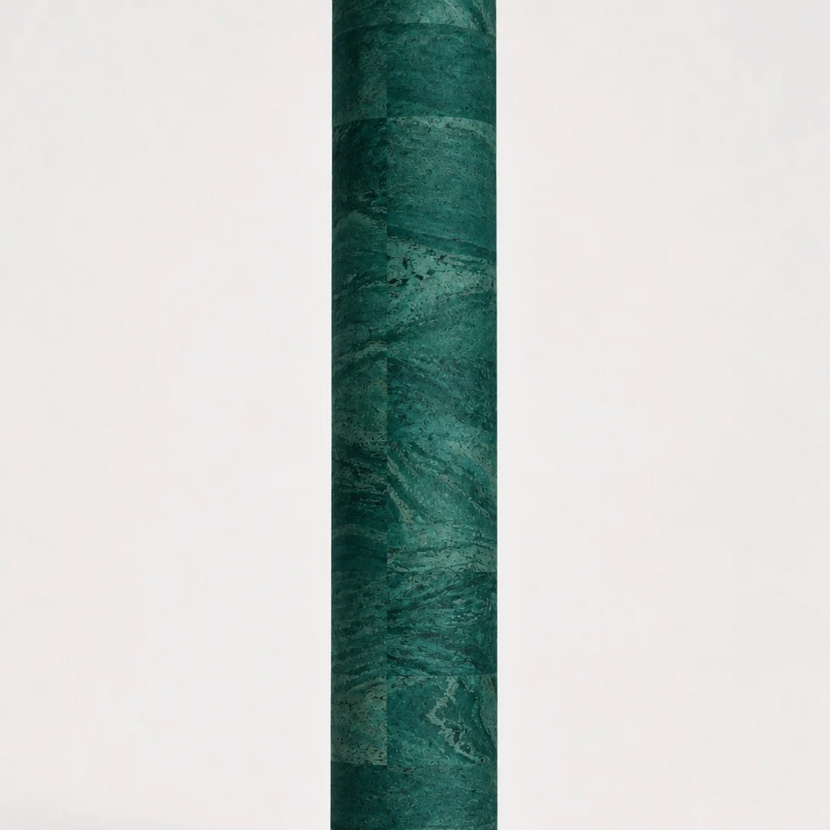 Rolled ThriveLiv natural cork yoga mat standing upright against a soft off-white studio background, showing the green cork pattern and texture.