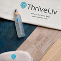 ThriveLiv lifestyle image featuring a cream branded carry bag, cork yoga mat grip spray and cream eye mask arranged across blue and natural cork yoga mats on a light wooden floor.