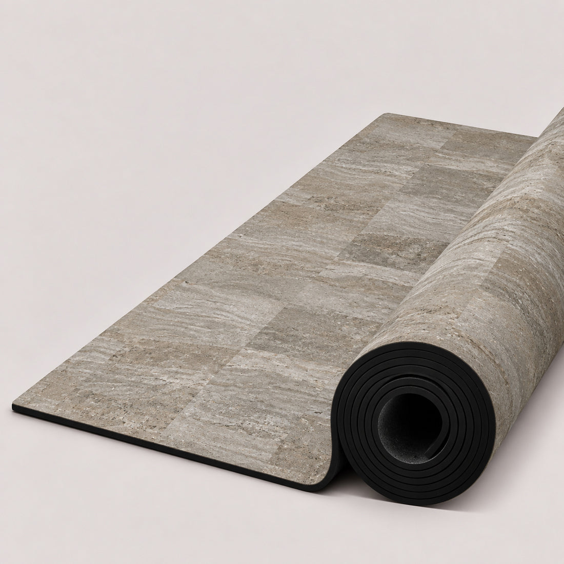 A rectangular yoga mat with a light gray stone tile pattern, partially unrolled to show its black textured underside, featuring the ThriveLiv logo at the bottom.